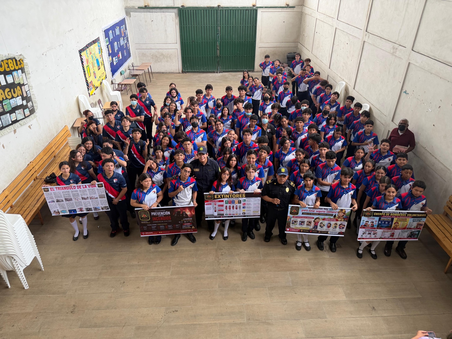 Students and firefighters together with fire-prevention and earthquake-safety posters